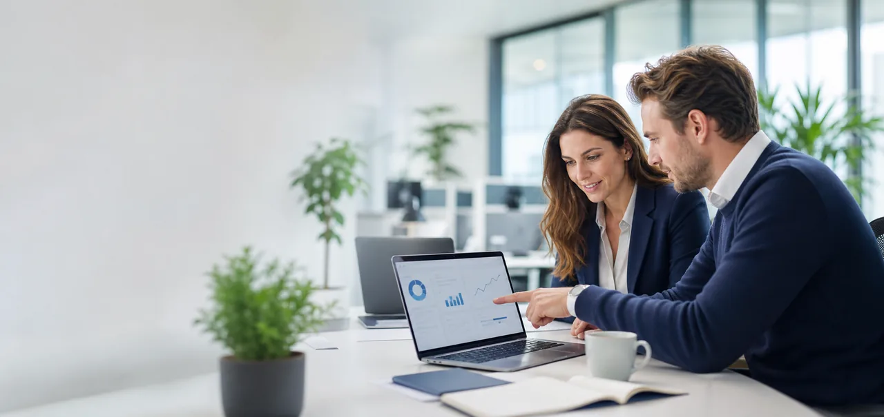 Sfeerbeeld: twee professionals bespreken cijfers op een laptop in een licht kantoor.
